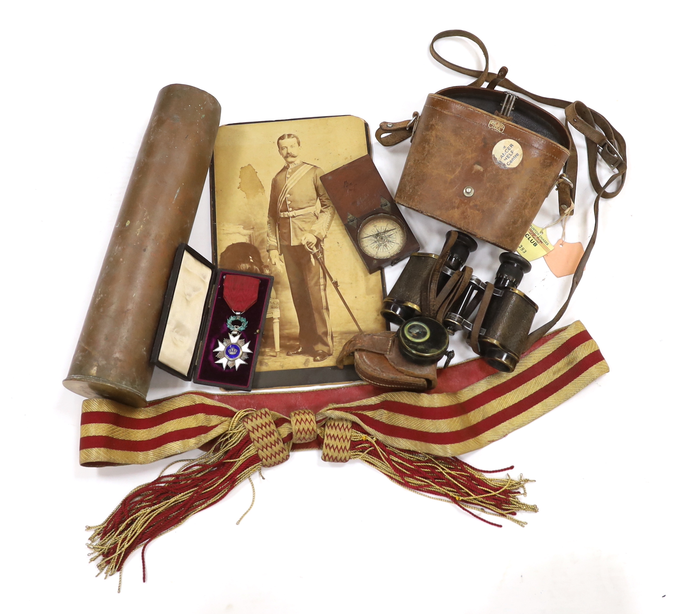 A late 19th century military sash with a related photograph showing the full uniform, a pair of Carl Zeiss binoculars, two compasses, a Belgium Order of the Crown cased medal, and a shell casing